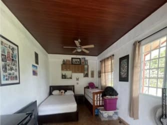 Bedroom featuring wood ceiling, natural light, ceiling fan, and family-friendly decor in Playa Gorgona Panama