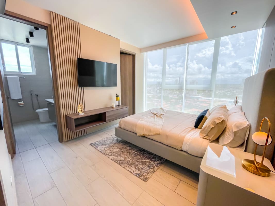 Modern master bedroom with ensuite bathroom, city skyline view, smart lighting in PH La Loma Panama City