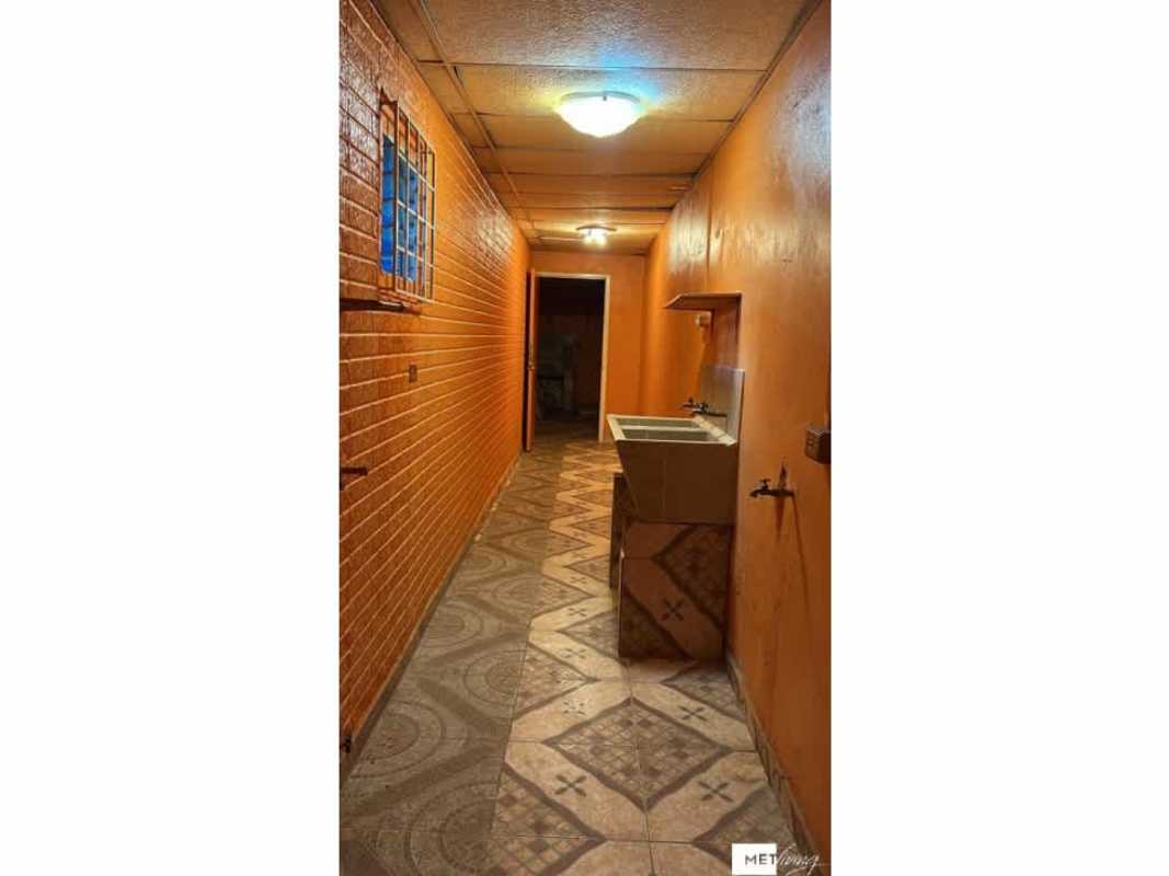 Bright corridor laundry area with sink, orange walls in Altos de Plaza Tocumen Panama