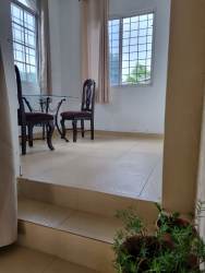 Dining area with beige curtains, glass table and chairs in El Carate house for sale Panama