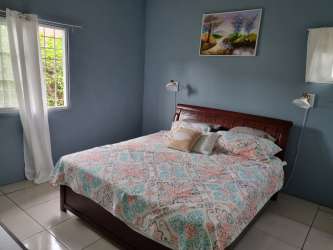 Bedroom with tiled floor, white walls, window and curtains El Carate Panama