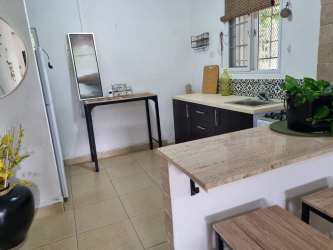Contemporary kitchen with marble counters, tile flooring, breakfast bar in El Carate house for sale Panama