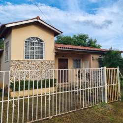 Traditional house in El Carate with arched windows, stone accent walls and fenced front yard Panama