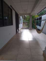 Covered carport and front yard with flowers at Residencial Miramar Chitré Panama