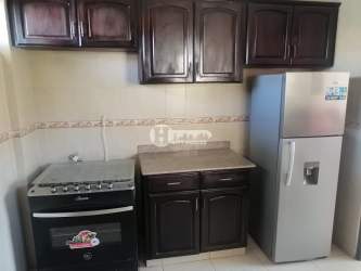 Kitchen featuring dark wood cabinets, granite countertop, gas stove and refrigerator in Villas del Golf Chitré Panama