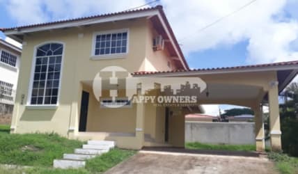 Exterior two-story house with carport, arched window and tiled roof in Villas del Golf Chitré Panama