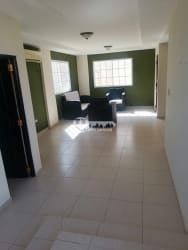 Spacious living room with accent wall, ceramic tiles, natural light in Villas del Golf Chitré Panama