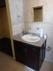 Bathroom with single sink vanity, mirror, tiled backsplash in Villas del Golf Chitré Panama