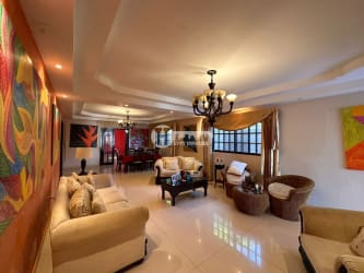 Living room with red accent wall, modern artwork, tile flooring, ceiling fans Los Santos Panama