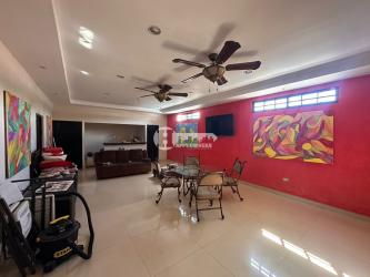 Spacious living area with sofas, chandeliers, tray ceiling and dining table in La Villa house Panama