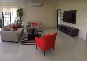 Contemporary living room with sofa set, TV, and access to terrace at Hacienda Pacifica house Panama