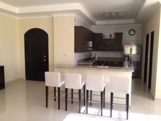 Contemporary kitchen with granite countertop island, dark wood cabinetry, and stainless steel appliances in Hacienda Pacifica