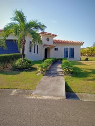 Exterior view of Mediterranean-style villa with terracotta roof, lush garden in Hacienda Pacifica Panama