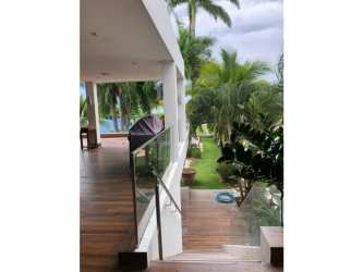 Luxury beachfront terrace with pool, wooden deck, tropical landscaping in Playa Blanca resort Panama