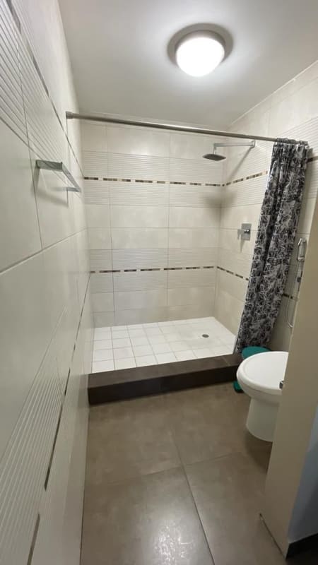 Minimalistic bathroom with tiled walk-in shower rain showerhead and toilet Condado del Rey Panama