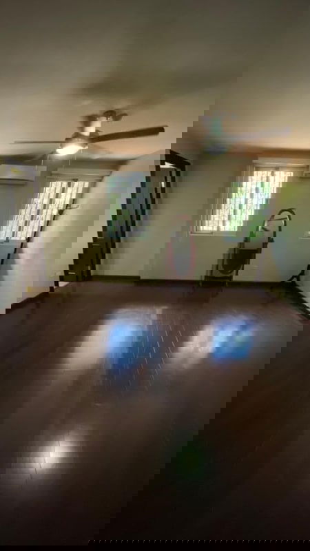 Spacious bedroom with wood floors windows ceiling fan AC unit and wardrobe Condado del Rey house