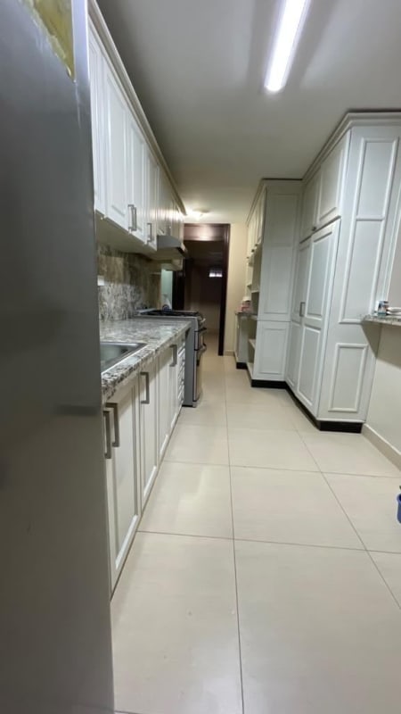 Kitchen with marble counter white cabinets tile floor built-in stove Condado del Rey duplex house