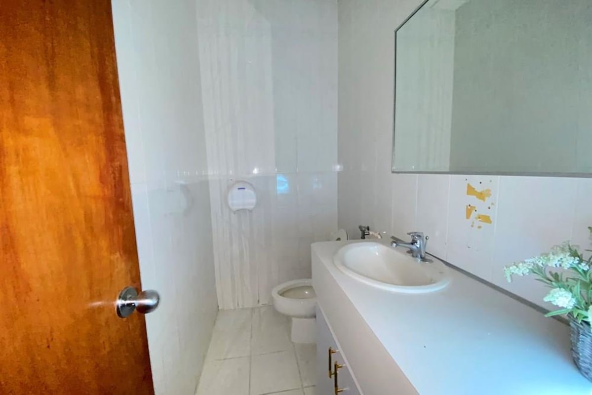 White bathroom with mirror and vanity in PH BICSA Financial Center Panama City