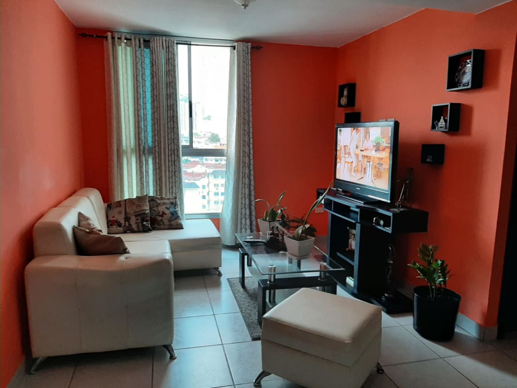 Orange accent wall, bright living room open to dining at PH Parque Lefevre Panama City