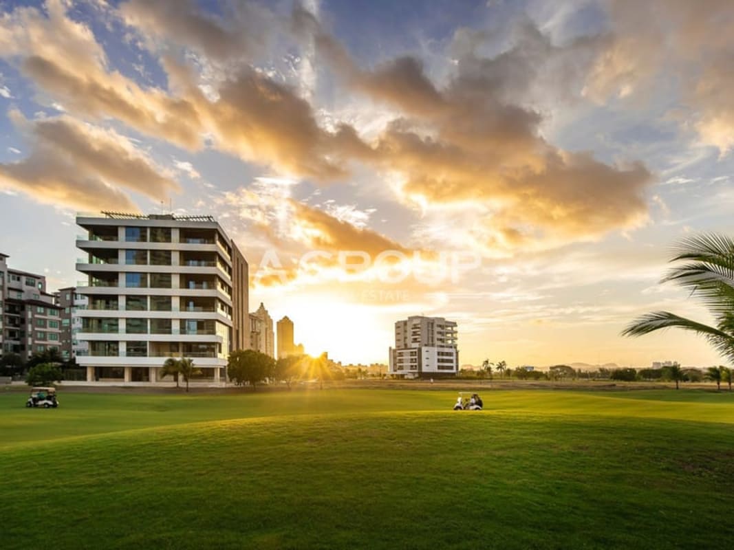 Modern golf course apartments overlooking lush green lawns and sunset sky in Lakeview Santa María, Panama City