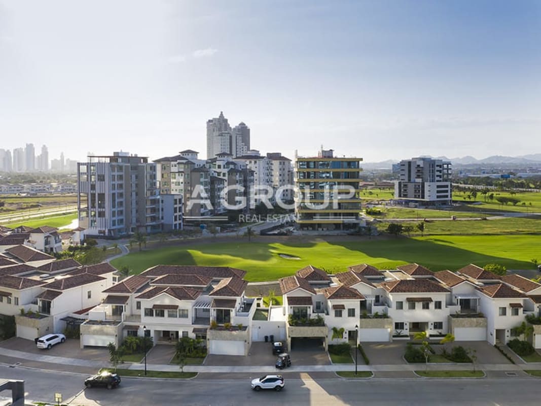 Suburban townhouses, modern condos, expansive golf course with green lawns, and skyline in Santa María Lakeview Panama