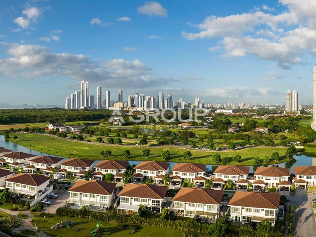 Aerial of upscale residential villas, water canals and far skyline Santa María