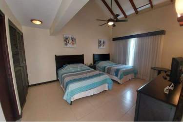 Bright bedroom with double beds and vaulted ceiling in Decameron Golf Villas Farallón Panama