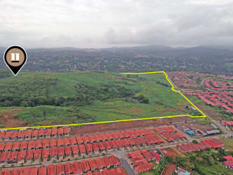 Expansive vacant hillside land with trees and access paths ready for development in Arraijan Panama