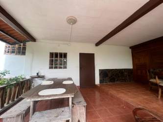 Rustic living room with exposed wooden beams, large windows, traditional decor in Costa Esmeralda San Carlos Panama