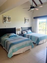 Two-story Mediterranean beach house with tile roof tropical landscape in Villas Decameron Panama