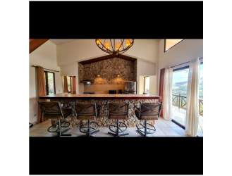 Spacious kitchen with stone accents, large center island, bar stools in mountain villa Altos del María Panama