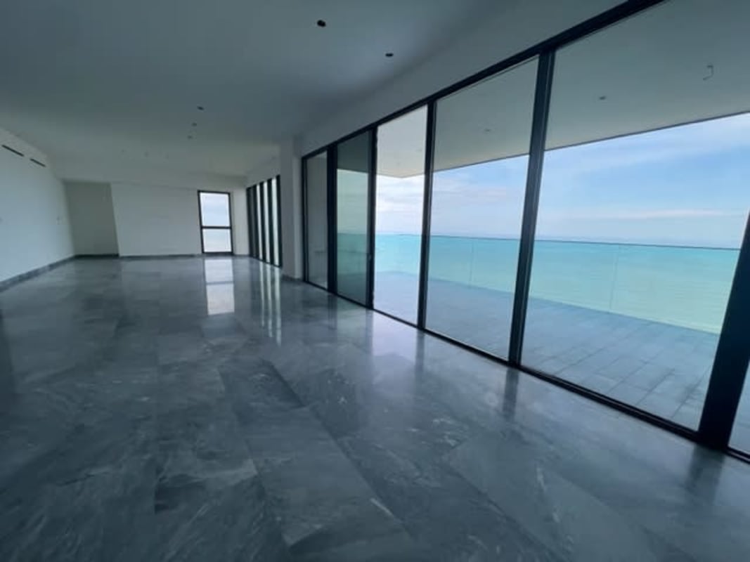 Spacious living area with floor-to-ceiling glass and marble flooring with sea view Upper East Tower apartment Panama
