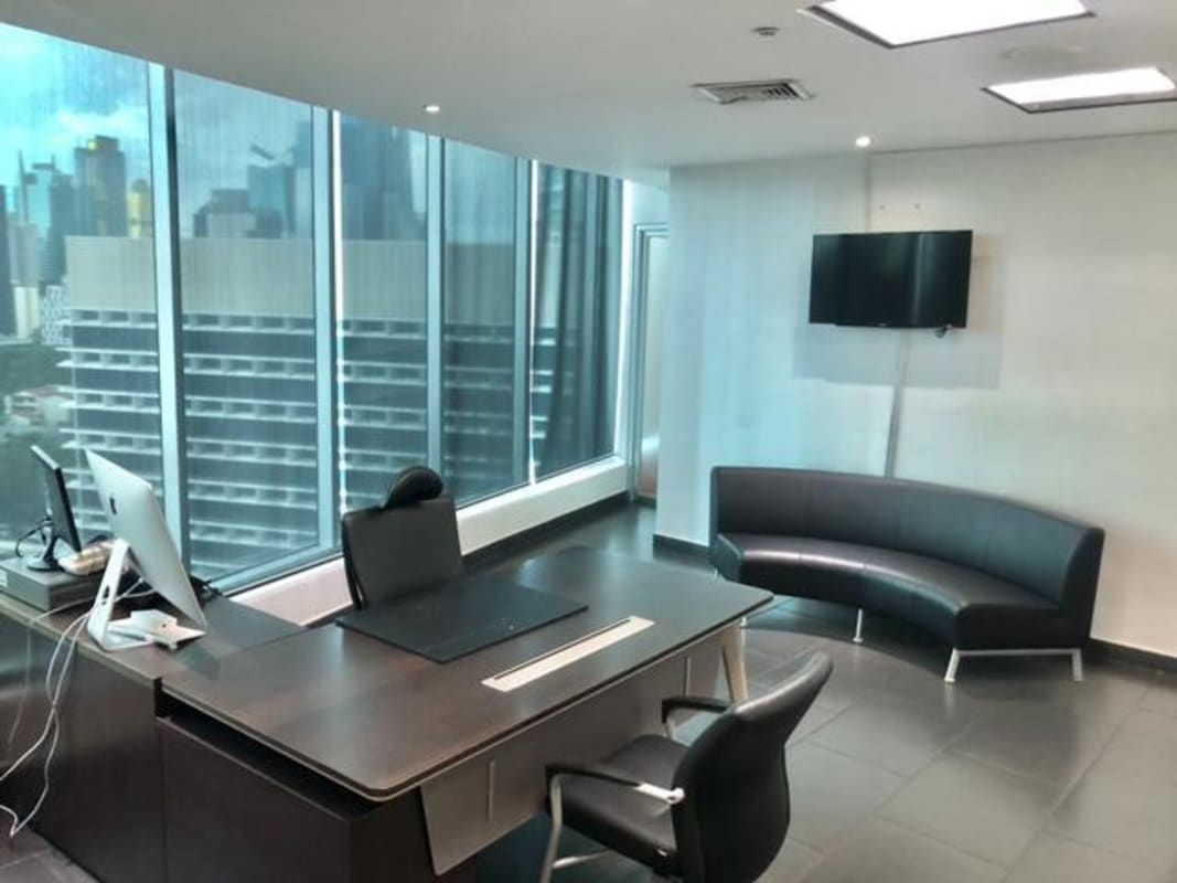 Modern office with city views large windows desk sofa and TV in Ocean Business Plaza Panama City