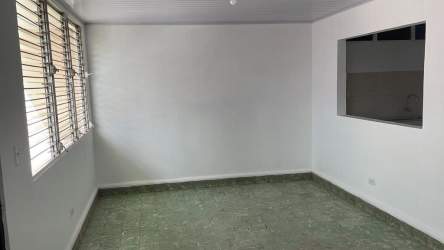 Open living or reception room with green tile floor and window downtown Chitré rental space