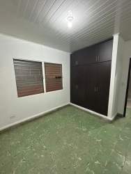 Room with green tile floor built-in closet in Aurosport building downtown Chitré