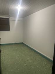 Unfurnished room green tile floor white walls window Aurosport building Chitré