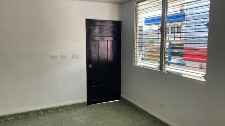 Bright interior room with green tiles, secure window bars commercial apartment Chitré