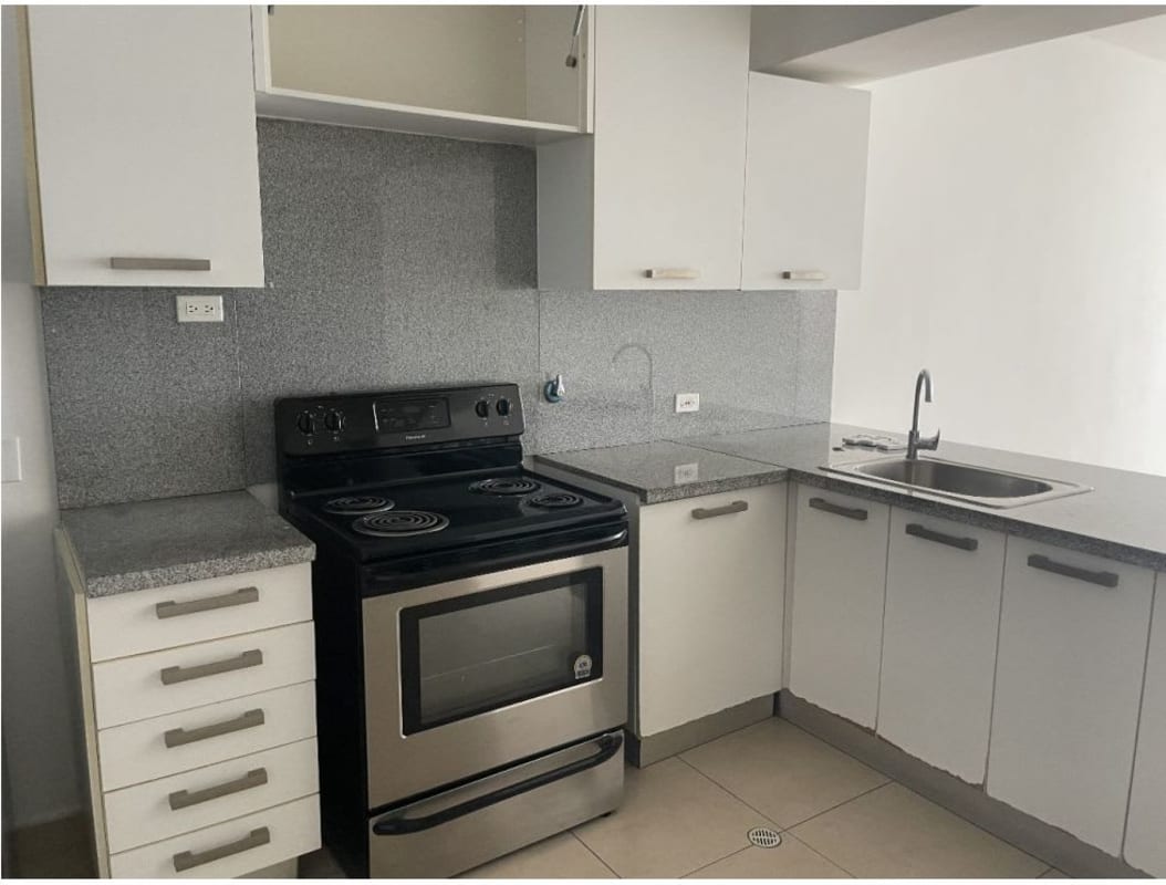 Modern apartment kitchen with granite countertops, electric stove, stainless steel fridge in PH White Panama City