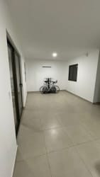 Modern interior with large sliding glass door and exercise bike Woodlands Panama Pacifico