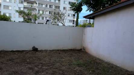 Dining space with glass table and open kitchen at Woodlands townhouse Panama Pacifico