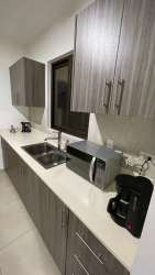 Modern kitchen with gray cabinets white countertops townhouse Woodlands Panama Pacifico