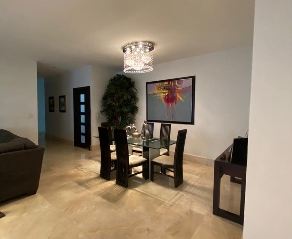 Formal dining room with glass table, marble floors, modern chandelier in Panama El Carmen house