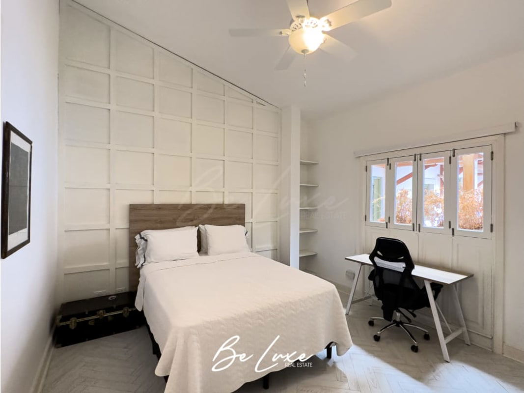 Modern living room with exposed stone wall, ceiling fan, wood floors PH Callejón de Chicheme Casco Viejo Panama