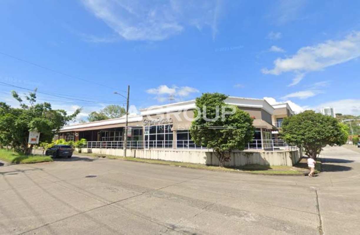 Modern commercial center facade with glass windows, two levels, parking Condado del Rey