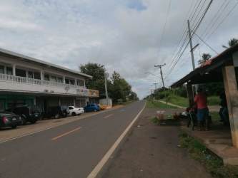 Two-story roadside commercial building with bus stop shelter Aguadulce Panama