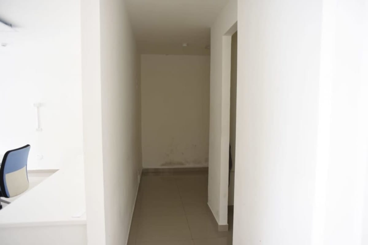 Interior hall with white walls, marble floors, emergency exit signage in Obarrio Plaza Panama