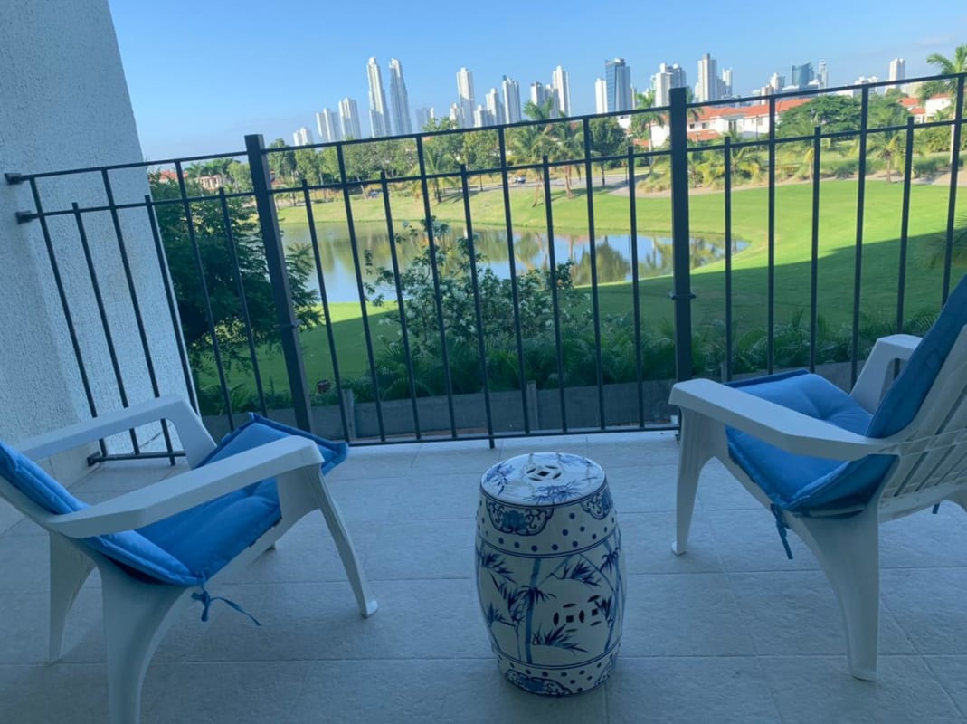 Modern living room with panoramic windows facing golf and lake in The Reserve Santa María, Panama