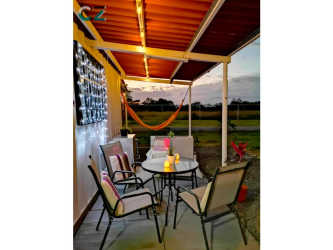 Covered patio with colorful seating overlooking grass lot and fencing in Coclé Panama