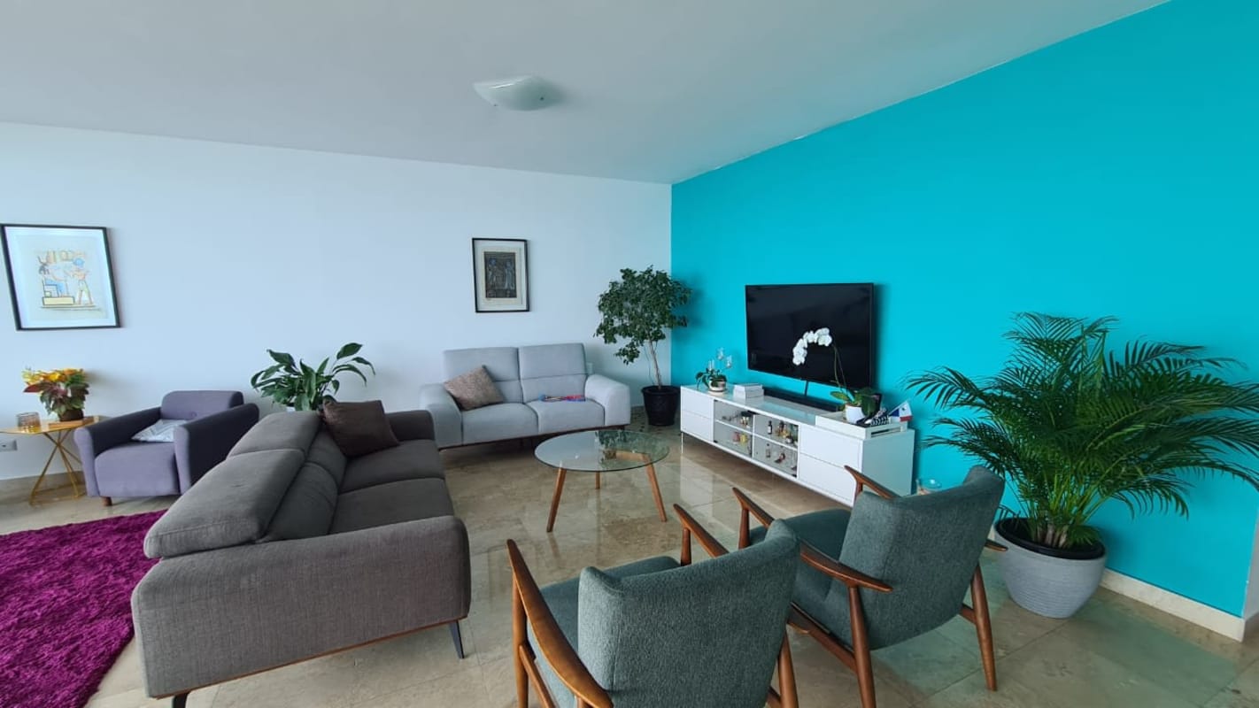 Contemporary living area with turquoise wall and ocean view PH Pearl on the Sea Costa del Este