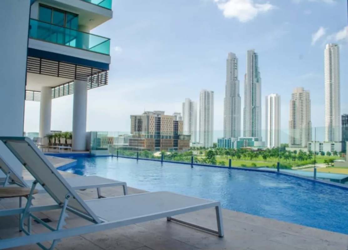 Infinity swimming pool and relaxing lounge deck with skyline at PH Park Lane Costa del Este Panama